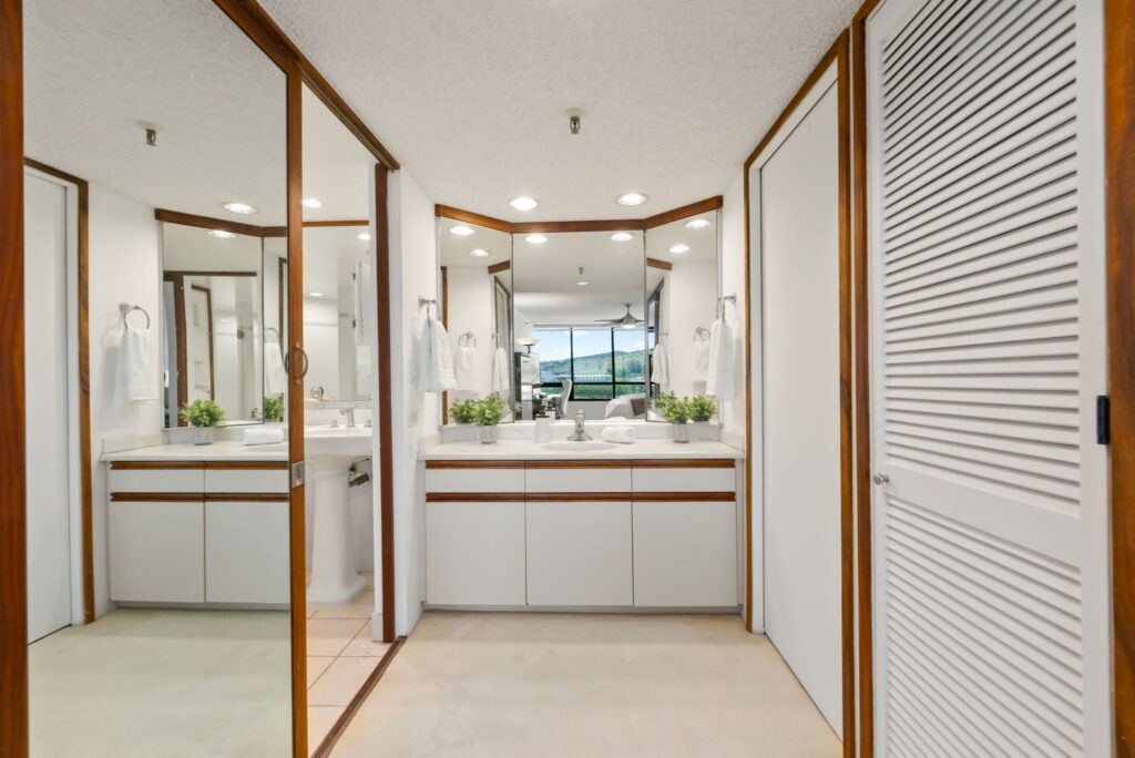 Primary suite vanity area with mirrored closets and storage.