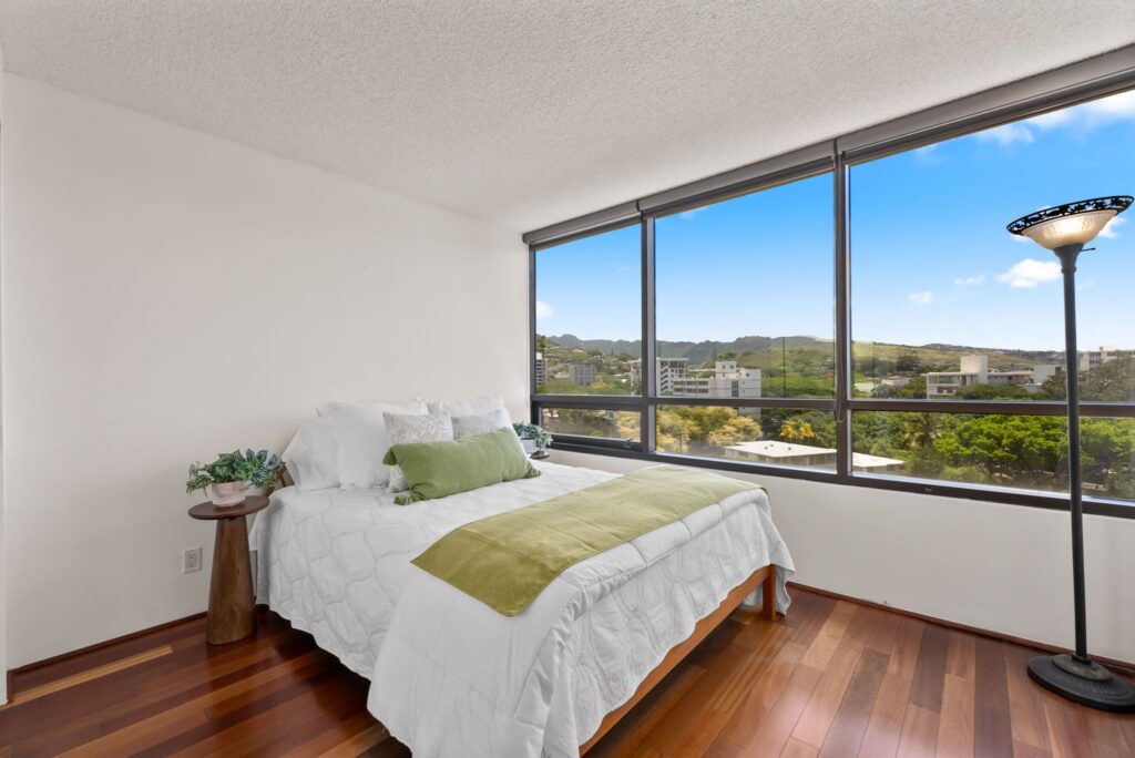 Guest bedroom with hardwood flooring and peaceful mountain views.