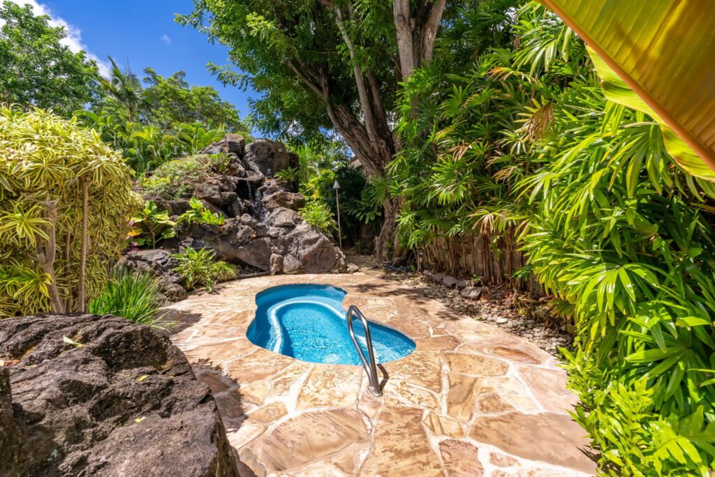 Tropical spa surrounded by mature landscaping and lava rock features at Punahou Cliffs
