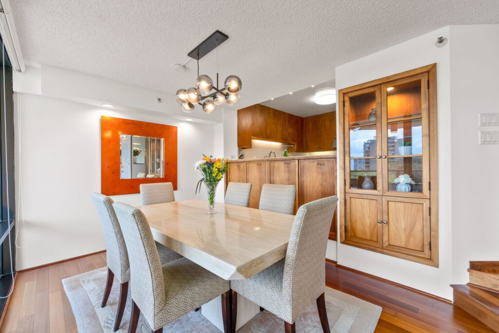 Dining area with custom Koa cabinetry and adjoining kitchen.