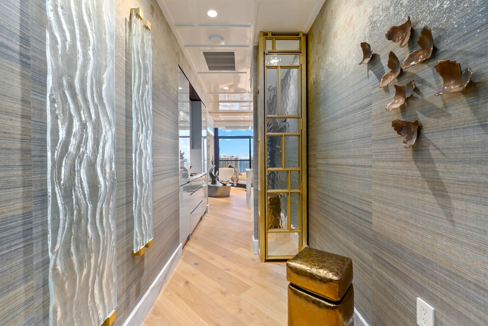 Custom entry hallway at Victoria Place Grand Penthouse 4003 with European White Oak flooring and brass glass details